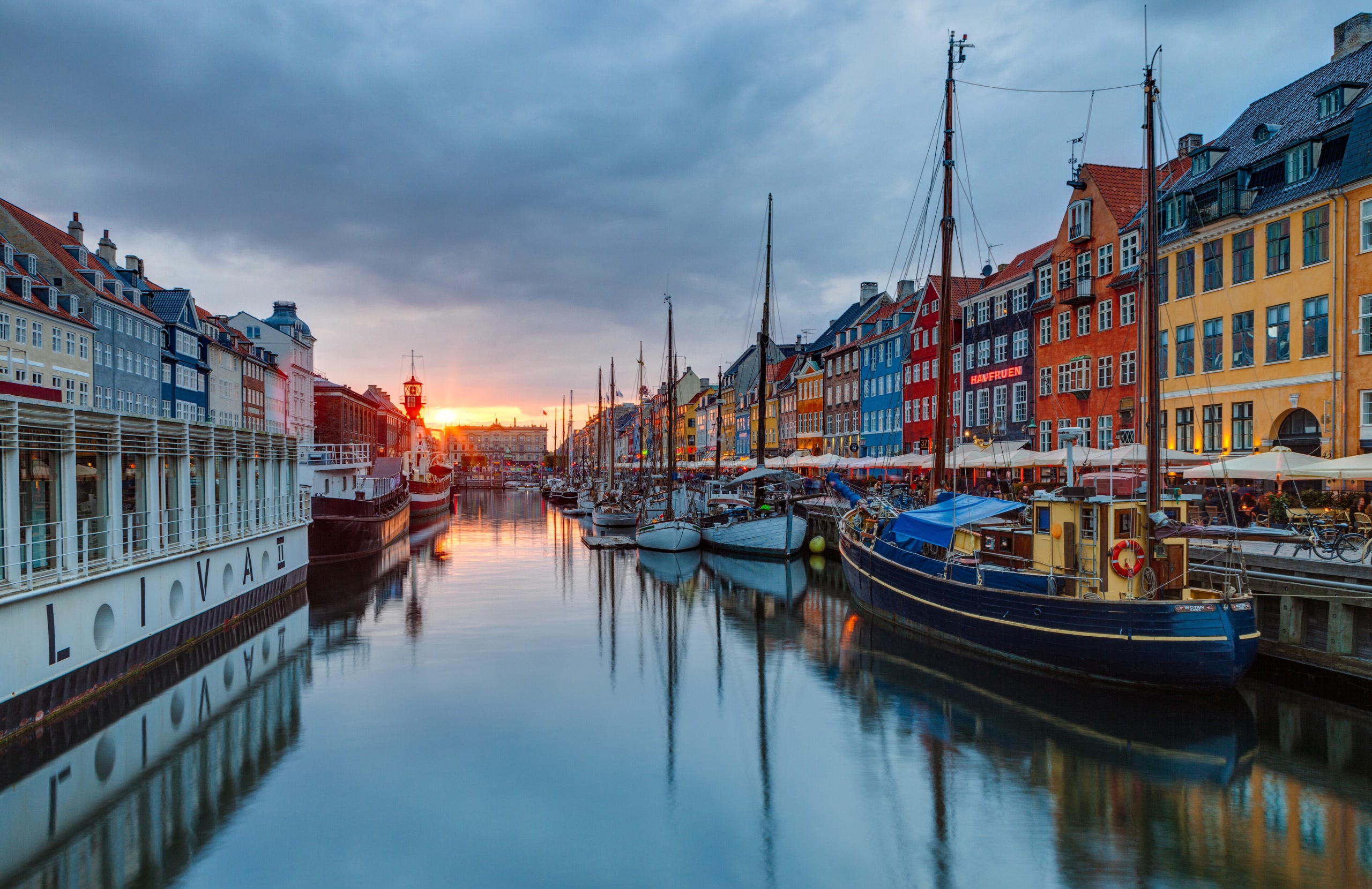Colourful gabled houses and boats along Copenhagen’s Nyhavn canal at sunset
