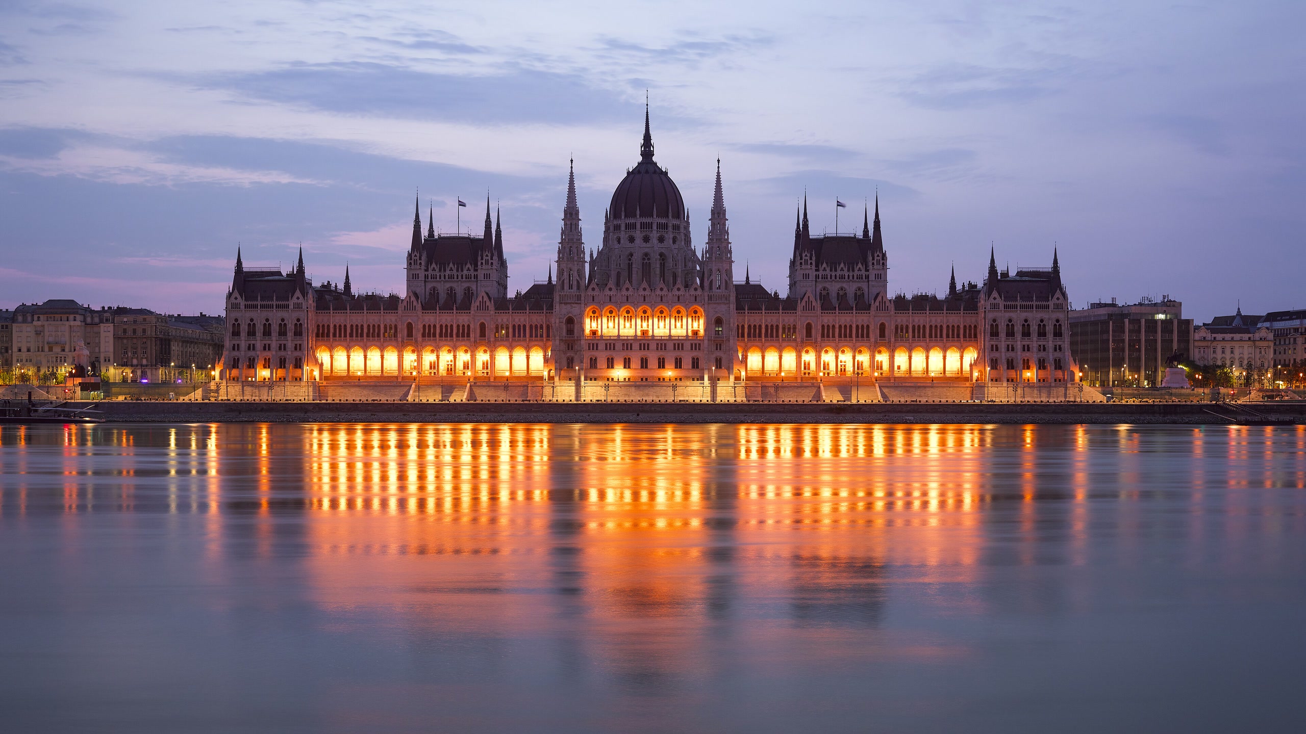 The illuminated Hungarian Parliament reflected in the Danube at dusk