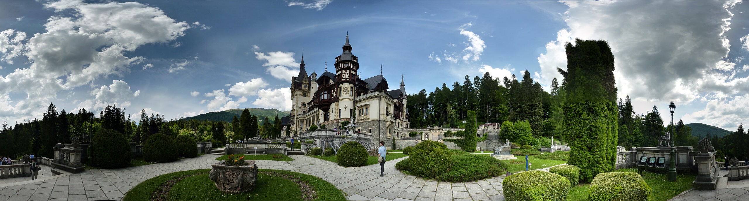 Peleș Castle beneath the forested Carpathian mountains