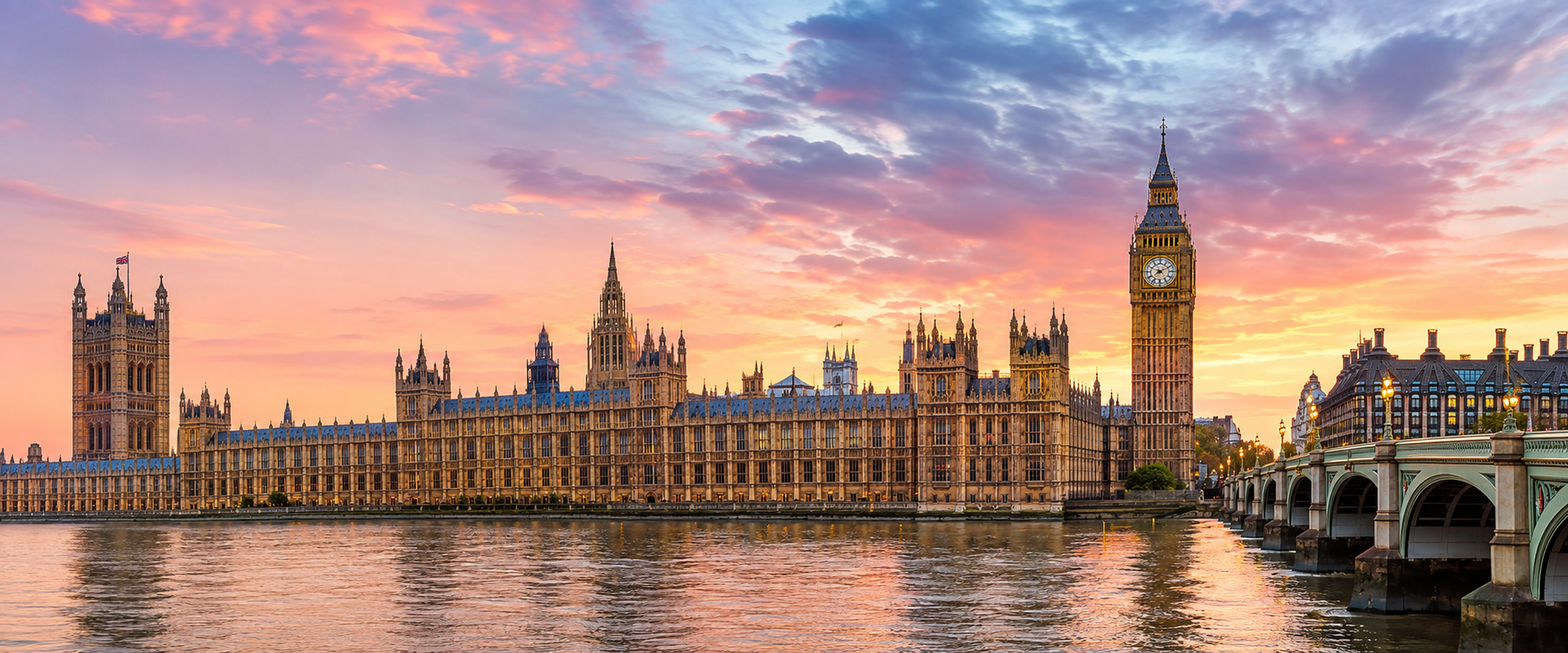 Big Ben and the Houses of Parliament beside the River Thames at sunset