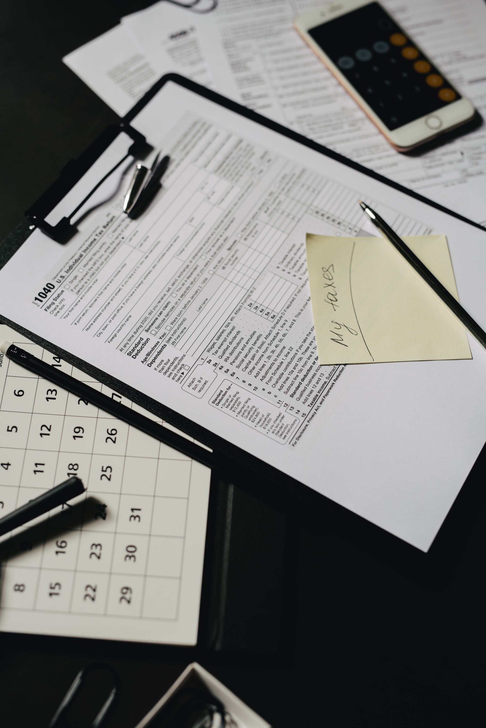 Tax documents and a calculator on a desk