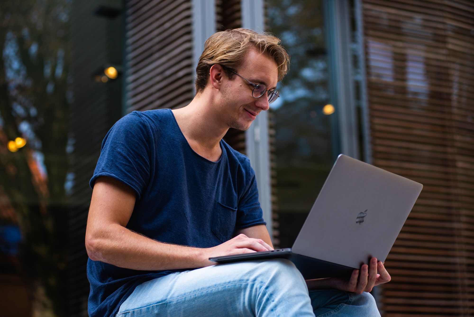 A student working on a laptop outdoors